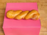 A glazed twist on a pink box.